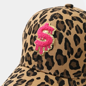 Detailed view of pink dollar sign towel embroidery on leopard print baseball cap