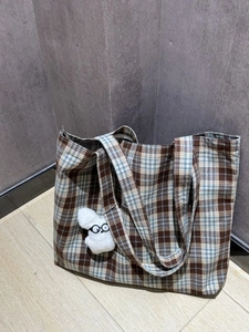 Close-up of vintage plaid canvas wallet with a cute plush bunny charm and eyeglass detail