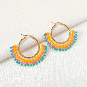 Detailed macro view of handmade seed bead earrings with colorful fan-shaped patterns
