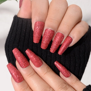 Macro shot of long coffin fake nails with sparkling red glitter and matte finish texture