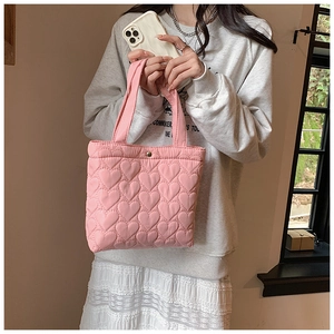 Close-up of pink heart-quilted oxford fabric handbag showing fine texture and stitching