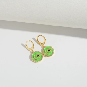 Macro detail of gold evil eye and moon earrings with green enamel and zircons