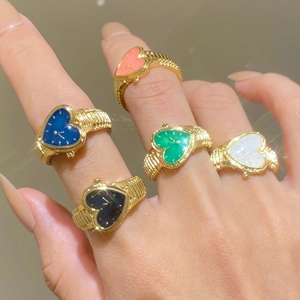 Detailed close-up of heart-shaped gold watch rings in vibrant enamel colors