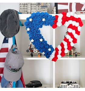 Detail of heart-shaped USA Independence Day wreath with red white blue roses on a shelf