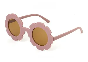 Side view of pink flower-shaped children's sunglasses with brown UV protective lenses