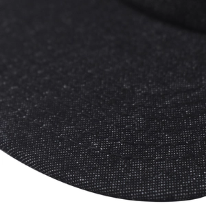 Macro shot of black denim fabric texture with curved white stitching detail on a cap