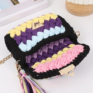 Macro detail of hand-woven colorful bag with triangular metal clasp and gold chain