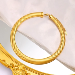 Close-up of 18K gold-plated chunky snake chain necklace with K18 tag on white satin