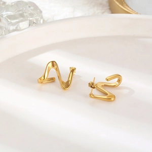 Detail shot of vintage gold geometric earrings with a unique twisted wave pattern design