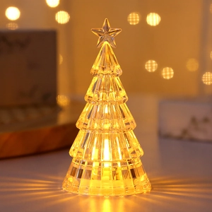 Close-up of glowing crystal Christmas tree night light with warm LED star topper