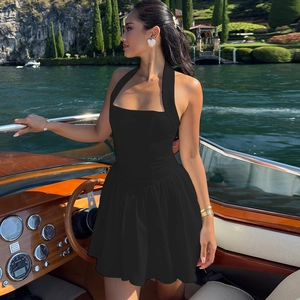 Robe mini noire dos nu élégante avec coupe ajustée présentée sur un yacht de luxe