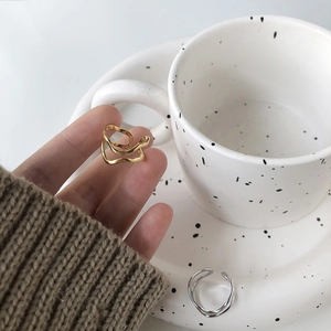 Detailed view of wavy irregular double-line V-shaped steel rings in gold and silver