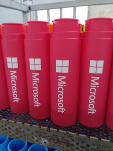 Macro shot of rose red foldable silicone bottle with white logo on blue rack