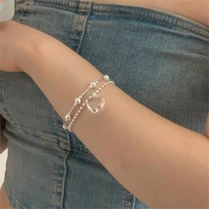 Close-up of a double-layer 925 sterling silver beaded bracelet with heart pendant