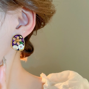 Detailed close-up of French vintage floral stud earrings with purple enamel and pearls