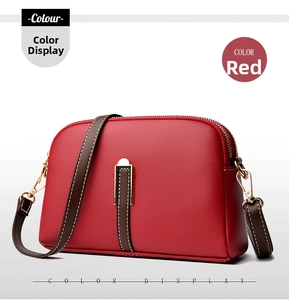 Close-up of red lychee texture leather shell bag with white stitching and gold hardware