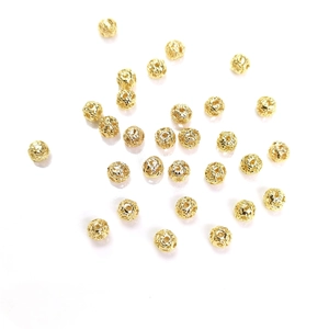 Primer plano de cuentas huecas de oro de 14k con patrones para crear joyas artesanales