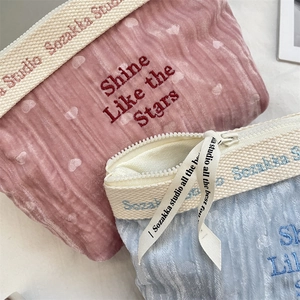 Detail of velvet makeup bags showing textured fabric and Shine Like the Stars embroidery
