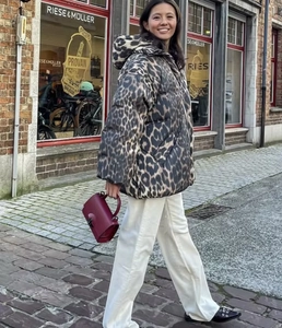 Streetstyle-Aufnahme einer dicken Leoparden-Pufferjacke mit Kapuze und lockerer Passform