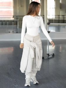 Detail of white ribbed long sleeve crop top paired with beige drawstring joggers outfit