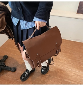 Detail of vintage brown leather satchel bag with silver buckles and handle strap