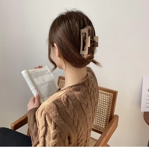 Matte brown oversized hair claw clip for elegant updo hairstyles on a female model