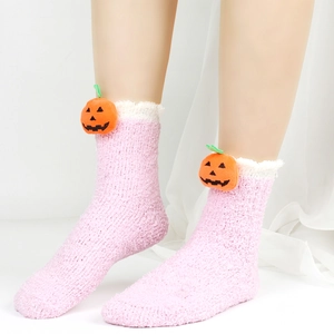 Detail von rosa Korallenvlies-Socken mit einer niedlichen 3D-Kürbispuppe für Halloween