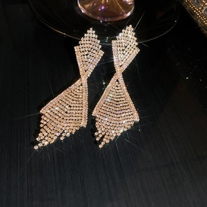 Macro detail of long tassel rhinestone earrings with sparkling starburst light effects
