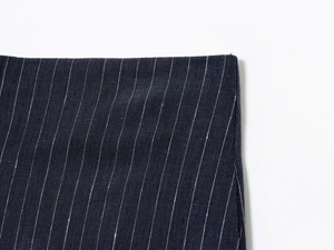Detailed close-up of dark blue pinstriped linen blend fabric with premium stitching details