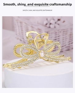 Close-up of golden bow hair claw clip with sparkling rhinestones and center pearl inlay
