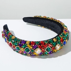 Détail de strass colorés facettés sur un serre-tête en velours noir rembourré