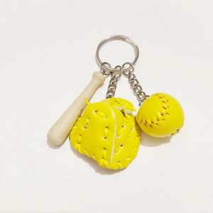 Close-up of yellow baseball glove and ball with wooden bat on silver keychain