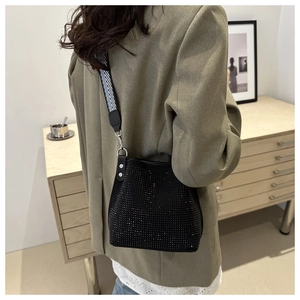 Detail of black rhinestone bucket bag with geometric patterned wide shoulder strap