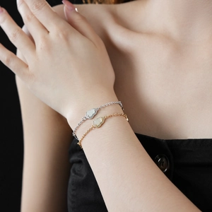 Detail of zircon hollow gourd bracelets in gold and silver finish worn on female wrist