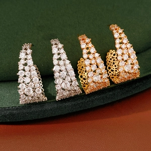 Vista macro di orecchini a U placcati in oro 18k e argento con micro-pave di zirconi cubici