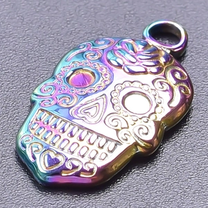 Macro detail of rainbow plated sugar skull pendant with intricate floral engravings