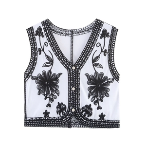 Detail of floral embroidery and hollow-out design on a white V-neck ethnic vest