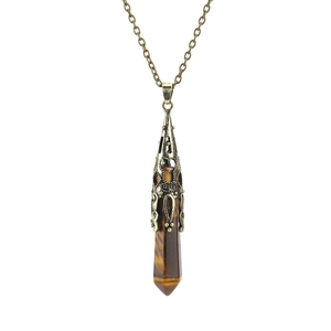 Detail of natural tiger eye crystal hexagonal pendant with vintage bronze cap and chain
