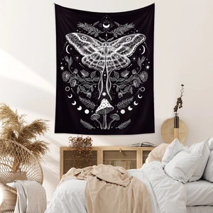 Detail of bohemian tapestry featuring moth, mushroom, and moon phase patterns on black
