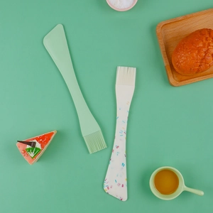 Silicone baking spatula and pastry brush detail shot in green kitchen theme setting.