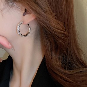 Close-up of model wearing silver hoop earrings with sparkling cubic zirconia crystals