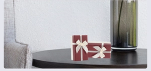 Detail of red rectangular lipstick gift boxes with textured surface and white ribbon bows