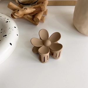 Detail of a matte khaki flower hair claw clip with elegant five-petal resin design