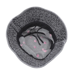 Detail view of denim bucket hat featuring pink butterfly embroidery and adjustable strap