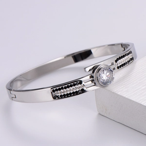 Macro shot of silver metal bangle with black and white zircon pavé and large round center stone