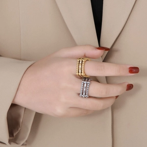 Macro detail of industrial triple-layer gear rings in gold and silver with inlaid diamonds