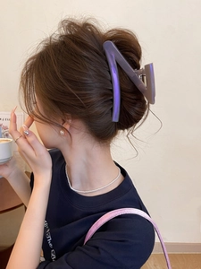 Detailed view of a purple translucent Z-shaped hair claw clip in a stylish hair bun