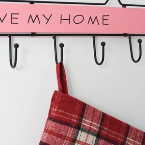 Detail of red Scottish plaid gift bag hanging on a pink Love My Home metal hook rack