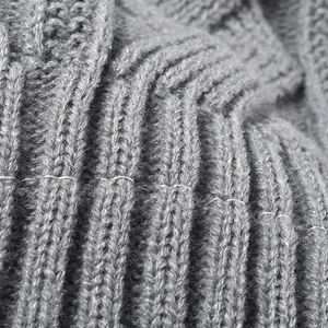 Close-up of thick light grey jacquard knit fabric with premium ribbed texture and soft wool