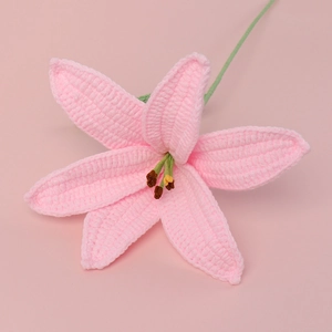 Detailed close-up of a pink hand-knitted crochet lily flower with green stem and brown stamen